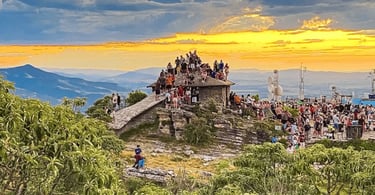 Mirante em São Thomé das Letras, MG, lotado de visitantes durante o pôr do sol com vista ampla