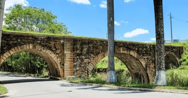 Pontilhão Dom Pedro II em Alfredo Vasconcelos visto da rua com arcos históricos e área verde