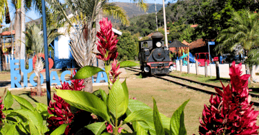 Flores, trem antigo e uma praça, Rio Acima, cidade turistica de Minas Gerais