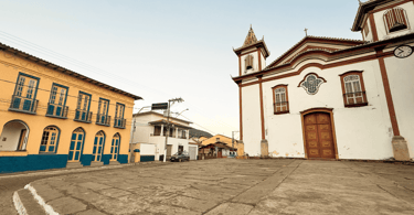Casarão histórico amarelo e azul, igreja Matriz de cor branca e vermelha em Conceição do Mato Dentro