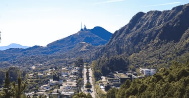 Vista de Belo Horizonte com bairro entre montanhas, área verde e Serra do Curral ao fundo