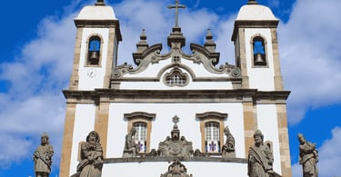 Fachada do Santuário do Bom Jesus, em Congonhas, com torres brancas e esculturas em pedra