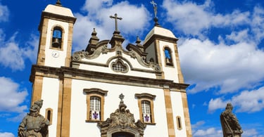 Basílica em Congonhas, com fachada branca e barroca, duas torres sineiras, esculturas em pedra