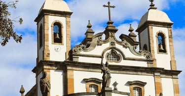 Parte frontal do Santuário do Bom Jesus de Matosinhos em Congonhas, torres, cruz central e profeta