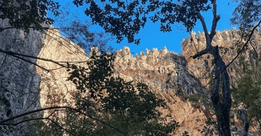 Gruta do Salitre em Diamantina MG com formações rochosas altas, vegetação sombreada e céu azul