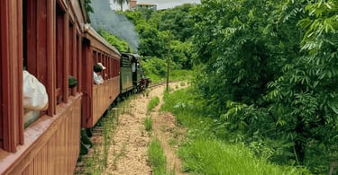 Vista da janela da Maria Fumaça, mostrando 2 vagões e a máquina principal, em São João del Rei