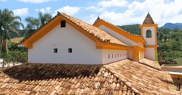 Vista de trás da igreja matriz de piedade do paraopeba, cores branca e amarelas, telhado marrom