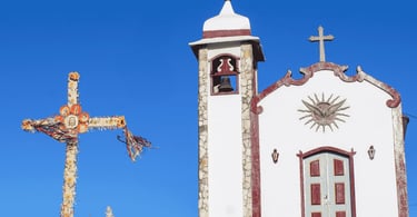 Igreja do Morro Redondo em Ipoema com cruzeiro colorido e céu azul de Minas Gerais
