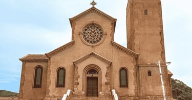 Igreja Matriz de Miguel Burnier vista de frente, com rosácea, torre lateral e escadaria na entrada
