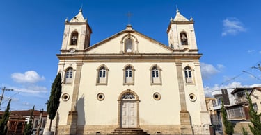 Fachada da Igreja Matriz de Nossa Senhora de Nazaré sob o céu azul em Nazareno, Minas Gerais