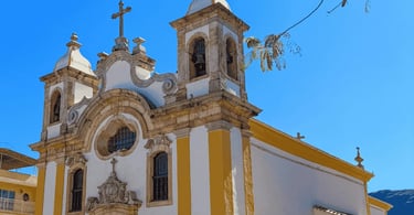 Igreja Matriz de Ouro Branco com cores amarelas e brancas, detalhes em pedra e sabão, duas torres