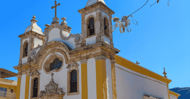 Igreja Matriz de Ouro Branco com cores amarelas e brancas, detalhes em pedra e sabão, duas torres