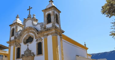 Igreja Matriz de Ouro Branco com fachada branca e amarela, torres sineiras e detalhes barrocos