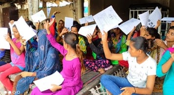 Girls holding up menstrual education information