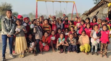 Pooja standing on the left of about fourty girls.