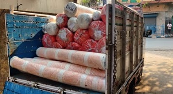 Large van with wooden sides delivering rolls of material