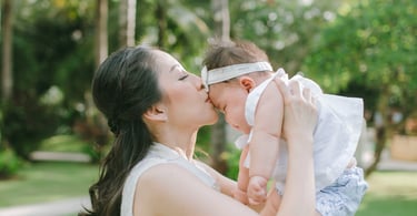 Mother lifting baby in garden during Sofitel Nusa Dua Bali family photography session