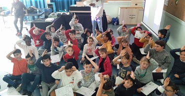 Une classe primaire qui fait le signe de reconnaissance du requin