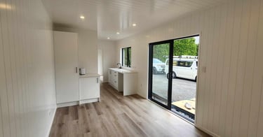 View of kitchen cupboard and sliding door of tiny home