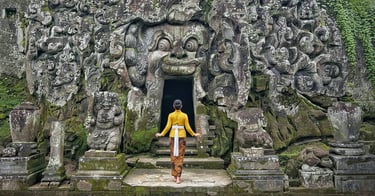 Entrance of Goa Gajah Temple in Ubud, Bali, featuring an ancient stone face carved into the rock
