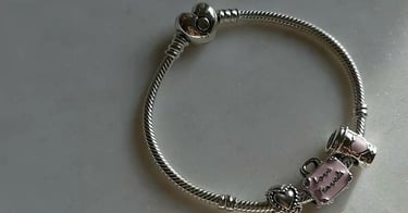 Pulsera de dijes Pandora de plata con cierre de corazón y dijes.