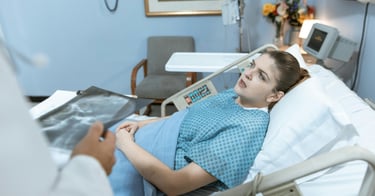 A woman in a hospital bed talking to her doctor