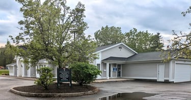 A grey commercial office building with a directory sign and Allstate Insurance office entrance.