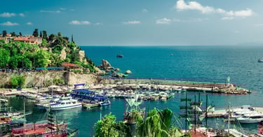 Vista do porto de Antália com o mar ao fundo e barcos ancorados ao longo do cais