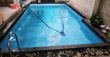 Proses mengvacum kolam renang.