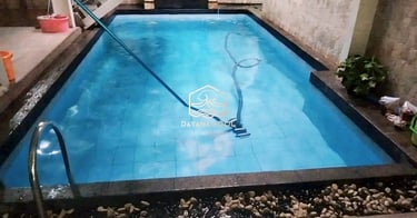 Proses mengvacum kolam renang.