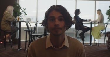 a man in a sweater and a woman in a chair