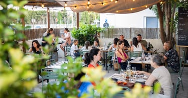 a group of people sitting at tables in a restaurant