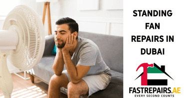 a man sitting on a couch with a fan in front of him