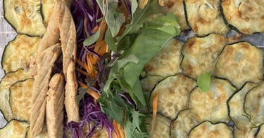 Wrap made of slices of overlapped courgette topped with grilled cheese and Quorn strips and salad