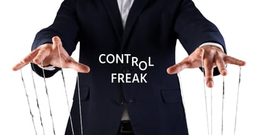 Businessman as a puppet master manipulating strings with Control Freak text overlay.