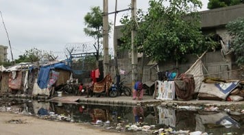 Slum dwellings and rubbish on a road.