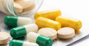 Close-up of pharmaceutical capsules being carefully inspected on a production line.
