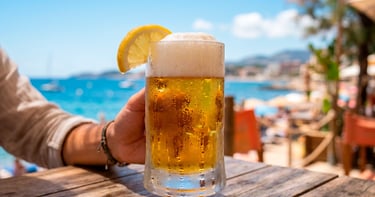 Vaso de cerveza dorada con espuma y rodaja de limón, representa la apuesta cervecera por opciones
