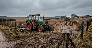 Tractor estacionado en campo con cartel “En venta”; simboliza la crisis agrícola en Alemania