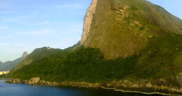 Navio de cruzeiro chegando ao Rio de Janeiro com o Pão de Açúcar ao fundo.