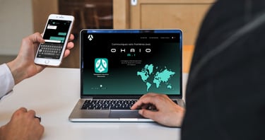 a man is holding a cell phone and a computer using ohaio chat