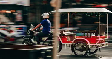 Cena típica do centro de Sihanoukville, com trânsito de bicicletas e tuk-tuks.