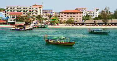 Cidade de Sihanoukville à beira-mar com casas ao fundo.