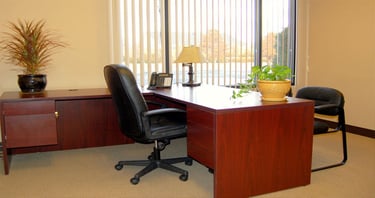 a desk with a chair and a lamp