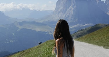 Magui fotografiada de espaldas viendo una montaña soleada