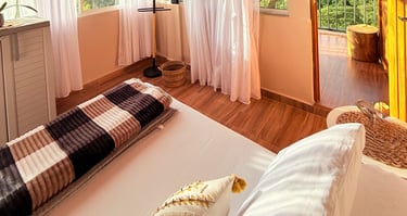 Habitación con cama doble, grandes ventanas con balcón