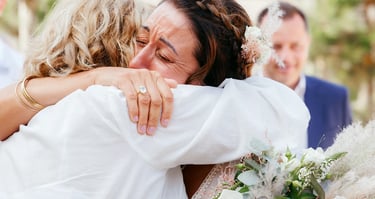 Photographie de mariée qui pleure de bonheur en serrant dans ses bras sa mère après la cérémonie de mariage, Talmont, Vendée