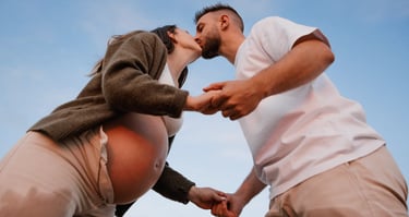 un couple s'embrasse tendrement lors d'une séance grossesse en couple sur la plage de la Paracou aux Sables d'Olonne