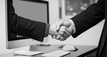 people shaking hands in front of a computer