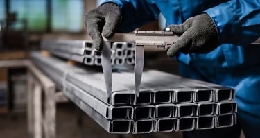 Worker checking the size of rectangular stainless steel pipes